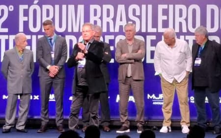 Oswaldo de Oliveira discursa em palco com Carlo Ancelotti