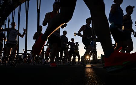 Competidores da Maratona de Sydney passam pela Harbour Bridge (Foto: Saeed KHAN / AFP)