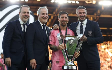 Lionel Messi com o troféu da MLS em mãos ao lado de Beckham e outros dois dirigentes