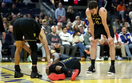 Jimmy Butler após colisão com Davion Mitchell e lesão no joelho, no Chase Center, em 19/1/2026 (Foto: Ezra Shaw/Getty Images/AFP)