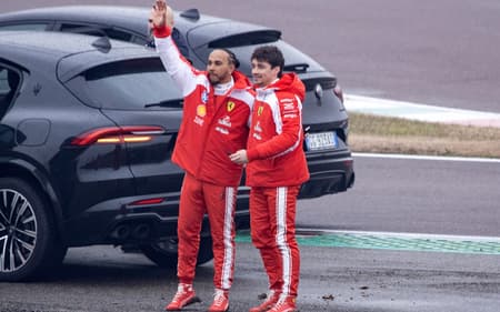 Lewis Hamilton e Charles Leclerc acenam para fãs após testarem a nova Ferrari SF-26 em Fiorano, em 23 de janeiro de 2026 (Foto: Federico Scoppa/AFP)