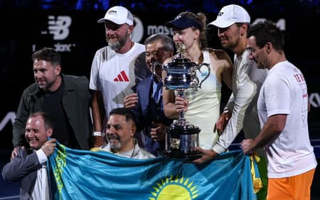 A cazaque Elena Rybakina posa com sua equipe após vencer o Australian Open pela primeira vez (Foto: IZHAR KHAN / AFP)