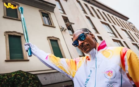 Snoop Dogg carregando a tocha olímpica em Gallarate, antes dos Jogos de Milão-Cortina 2026 (Foto: Handout/Milano Cortina 2026 Olympic Committee/AFP)