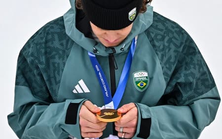 Lucas Pinheiro Braathen observa a medalha de ouro no pódio do slalom gigante masculino em 2026. (Foto: Fabrice Coffrini/AFP)
