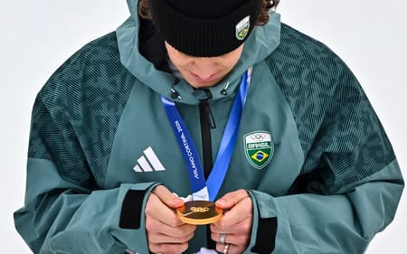 Lucas Pinheiro Braathen observa a medalha de ouro no pódio do slalom gigante masculino em 2026. (Foto: Fabrice Coffrini/AFP)