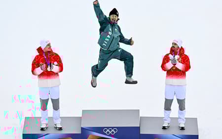 Da esquerda para a direita, Marco Odermatt (prata), Lucas Pinheiro Braathen (ouro) e Loic Meillard (bronze) celebram no pódio do slalom gigante masculino em 2026. (Foto: Fabrice Coffrini/AFP)