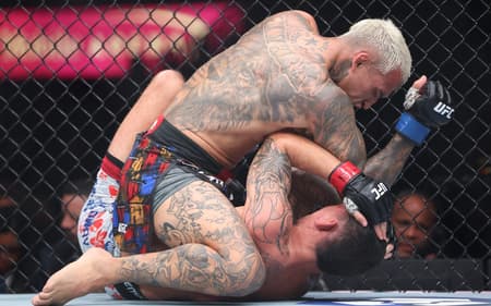 Charles "Do Bronx" Oliveira golpeia Max Holloway durante a luta pelo cinturão BMF no T-Mobile Arena. (Foto: Sean M. Haffey/Getty Images/AFP)