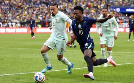 Vini Jr disputa a bola com Gusto em Brasil x França (Foto: FRANCK FIFE / AFP)