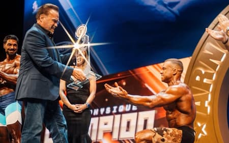 O brasileiro Vitor Chaves recebe troféu das mãos de Arnold Schwarzenegger