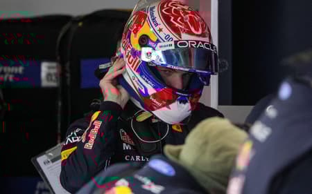 Max Verstappen, da Red Bull, ajusta o capacete nos boxes durante a classificação da sprint do GP da China de F1, em Xangai, em 13 de março de 2026 (Foto: Andy Wong/Pool/AFP)