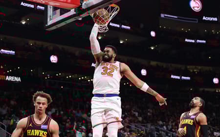 Karl-Anthony Towns, do New York Knicks, enterra sobre Dyson Daniels e Gabe Vincent, do Atlanta Hawks, na State Farm Arena. (Foto: Kevin C. Cox/Getty Images/AFP)