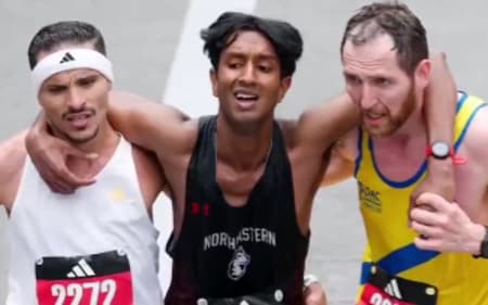 Brasileiro Robson Oliveira (e) socorre competidor na reta final da Maratona de Boston (Reprodução)