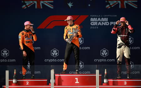 MIAMI, FLORIDA - MAY 04: Race winner Oscar Piastri of Australia and McLaren Second placed Lando Norris of Great Britain and McLaren and Third placed George Russell of Great Britain and Mercedes AMG Petronas F1 Team on the podium during the F1 Grand Prix of Miami at Miami International Autodrome on May 04, 2025 in Miami, Florida. Hector Vivas/Getty Images/AFP (Photo by Hector Vivas / GETTY IMAGES NORTH AMERICA / Getty Images via AFP)