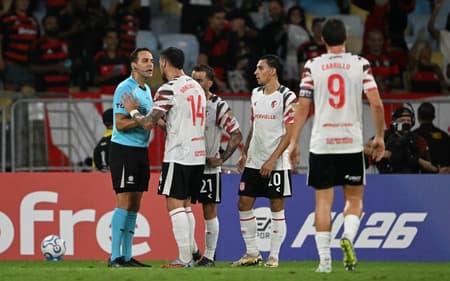 Jogadores do Estudiantes cobrando o árbitro após a marcação do pênalti contra o Flamengo