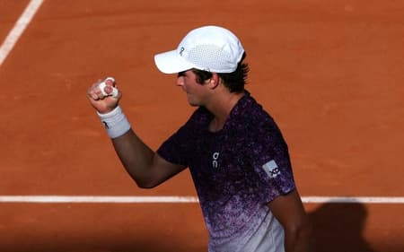 João Fonseca comemora ponto na estreia de Roland Garros contra o francês Luka Pavlovic (Foto: Alain JOCARD / AFP)