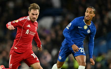 Mac Allister conduz a bola e é observado por João Pedro em Chelsea x Liverpool