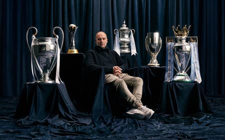 Pep Guardiola ao lado dos diferentes troféus conquistados com o Manchester City