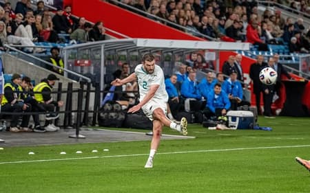 Zagueiro Tim Payne finaliza com a perna direita, que está suspensa no ar, e a bola flutua a sua frente