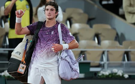 O brasileiro João Fonseca deixa a quadra após perder para o tcheco Jakub Mensik ao final da partida de quartas de final de simples masculina no décimo dia do torneio de tênis de Roland Garros, na quadra Philippe-Chatrier, em Paris (Foto: Thomas Samson / Afp)