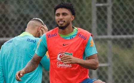 o volante Éderson se aquecendo com o colete laranja e uniforme verde de treino da seleção brasileira