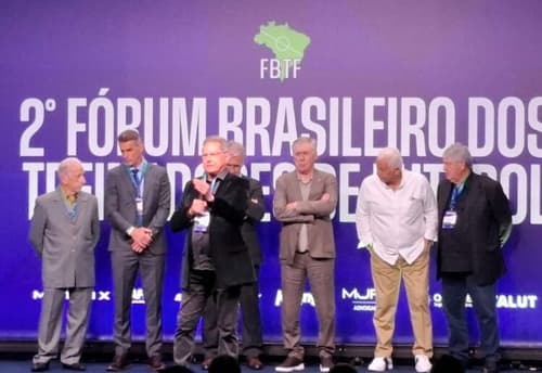 Oswaldo de Oliveira discursa em palco com Carlo Ancelotti