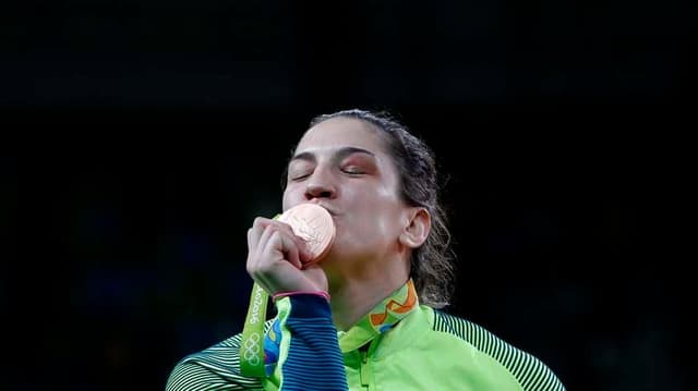 Mayra beija a medalha conquistada na quinta