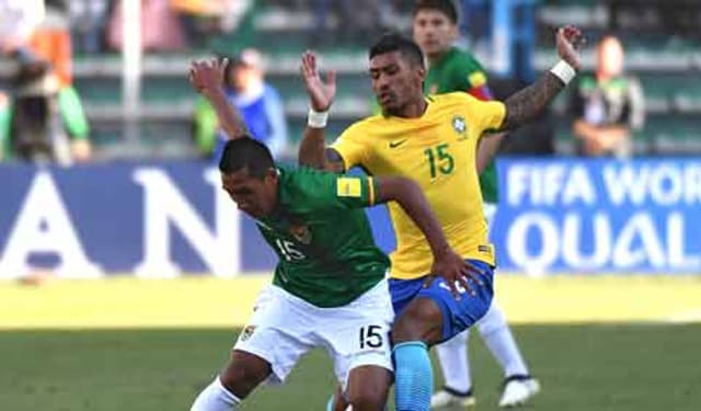 Paulinho disputa bola em jogo na Bolívia
