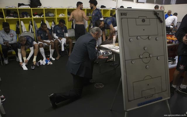 Elenco do Corinthians, e Tite ajoelhado, em vestiário (Foto: Daniel Augusto Jr)