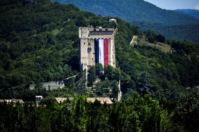 Bandeira da França aberta em um castelo para passagem dos ciclistas. Ato de protesto contra o terror