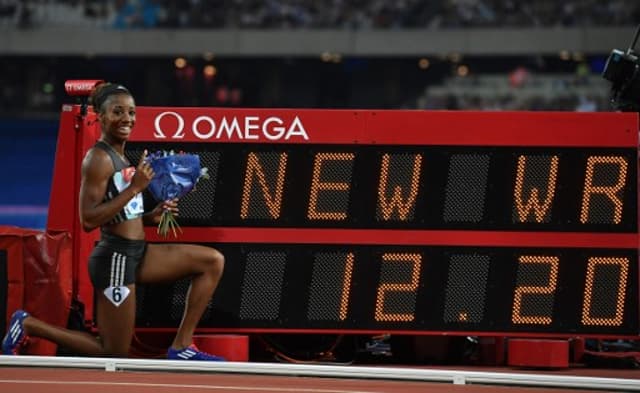 Kendra Harrison posa para foto ao lado do placar eletrônico com seu recorde mundial (Foto: AFP)