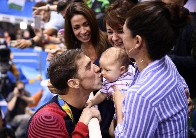 Michael Phelps beija o filho Boomer Robert após ouro no Rio<br>​