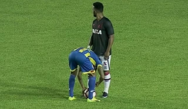 Irrazábal tentando desamarrar chuteira de Carlos Alberto