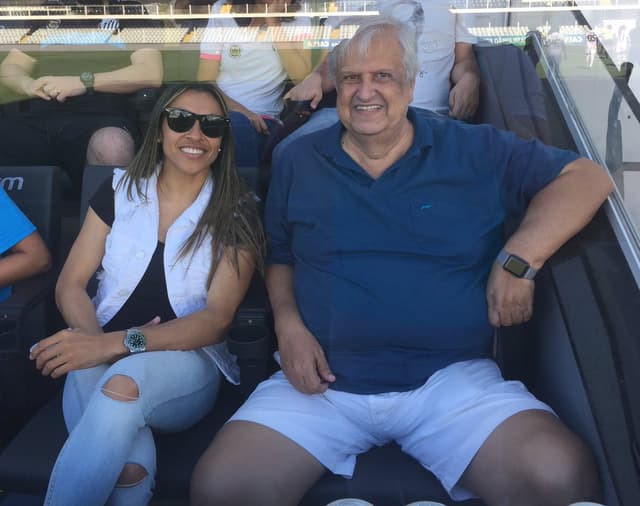 Marta ao lado de Modesto assistindo o jogo das Sereais