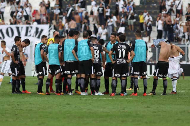 Jogadores reunidos ao fim do jogo no campo