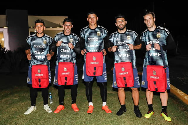 Jogadores posam com bolsa térmica que ganharam para carregar o mate