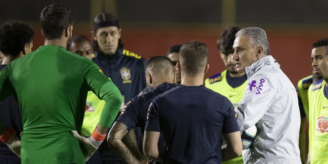 No detalhe, Cássio ao fundo usando moletom. O goleiro Alisson, de costas, usa a camisa verde da Seleção