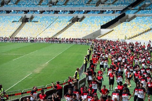 Atletas da corrida do Flamengo, a Nação Rubro Negra em Movimento, no gramado do Maracanã. (Divulgação)