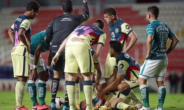 Nicolás Benedetti caído com a mão no joelho em León x América