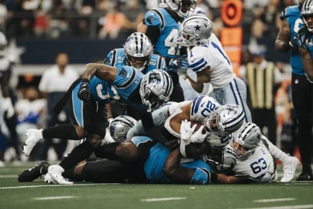 Tony Pollard avança sobre a forte linha defensiva de Carolina