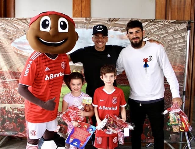 Taison e Bruno Méndez tirando foto em ação do Colorado no Dia das Crianças