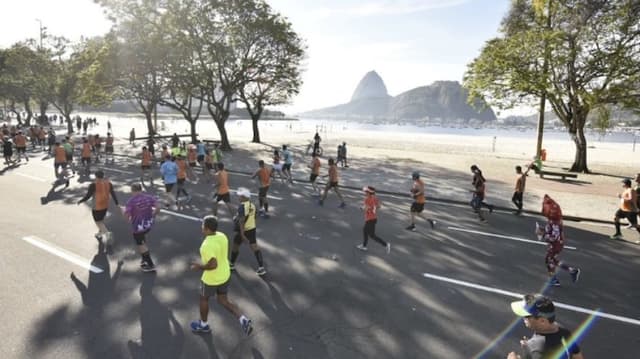 Corredores passam pelo Aterro do Flamengo com o Pão de Açúcar ao fundo durante a Maratona do Rio. (Divulgação)