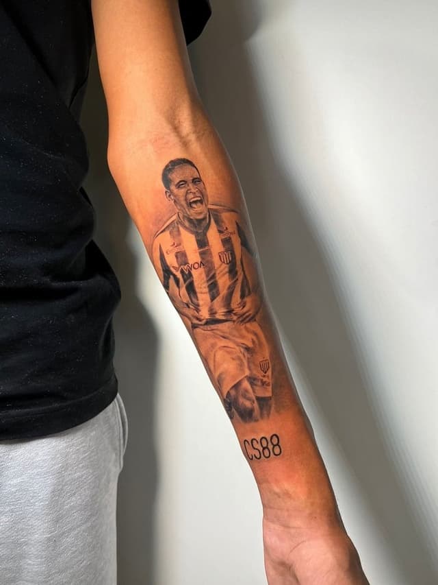 Tatuagem de Cléber Santana no braço do filho, Aroldo Neto