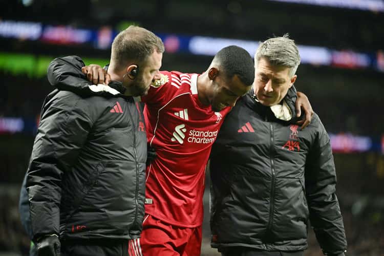 Isak deixa o jogo entre Tottenham e Liverpool amparado pelos médicos do clube após grave lesão no tornozelo