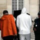 Benzema, de casaco branco, presta depoimento (Foto: Matthieu Alexandre / AFP)