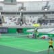 Tenistas em partida de duplas na arena olímpica.