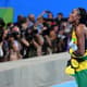 Elaine Thompson celebra com a bandeira da Jamaica após vitória nos 100m