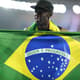 Na comemoração pelo inédito feito na Rio-2016, Usain Bolt exibe uma bandeira do Brasil