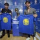Éverton Ribeiro e Diego posam com camisas do GSW ao lado do troféu da NBA