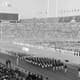 Diante das arquibancadas lotadas do Estádio Nacional de Tóquio, a delegação do Japão desfila na cerimônia de abertura dos Jogos de Tóquio-1964 (Crédito: COI)
