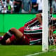 Ganso caído no gramado sendo festejado pelos companheiros de Fluminense